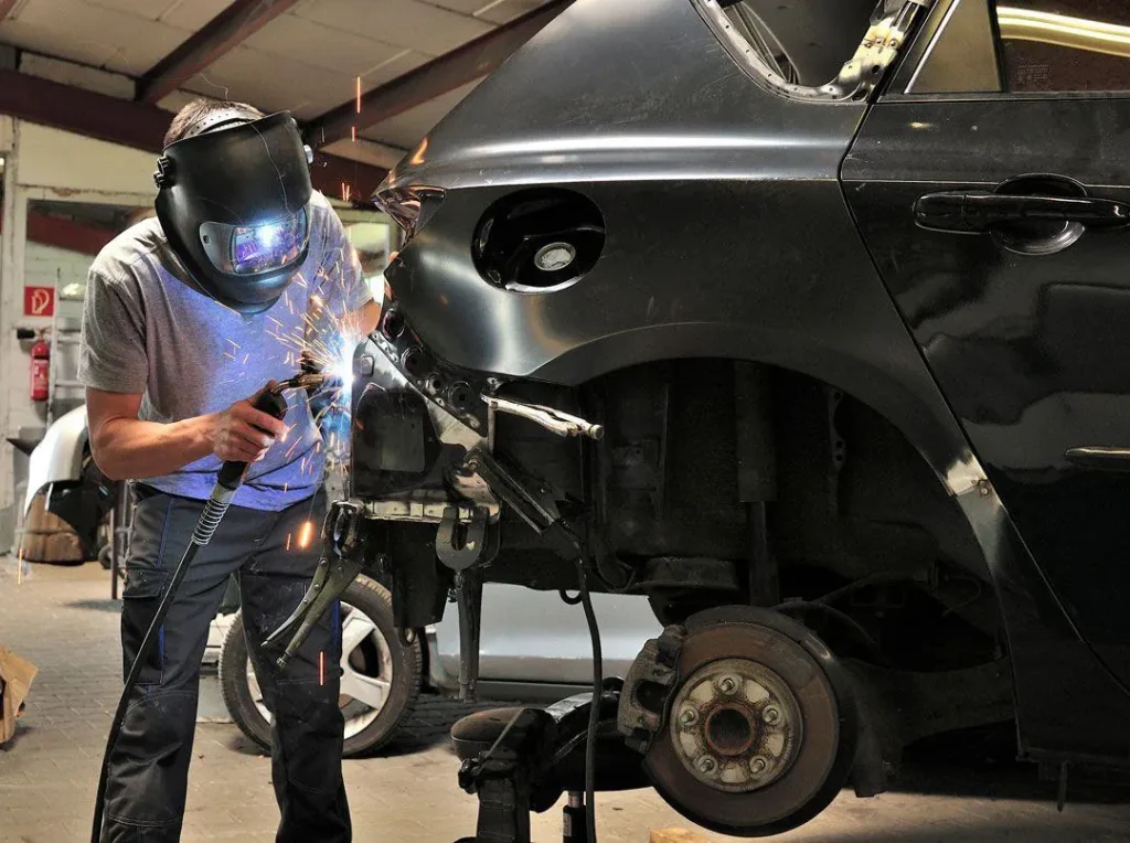 Technician welding a repaired rear quarter panel